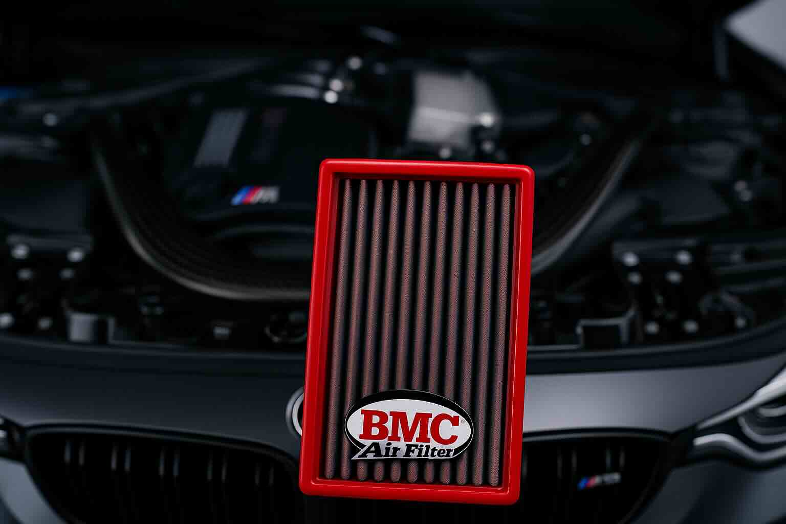Red BMC car air filter in front of a high-performance engine bay, showcasing washable and reusable design for BMW, Porsche, and luxury vehicles.